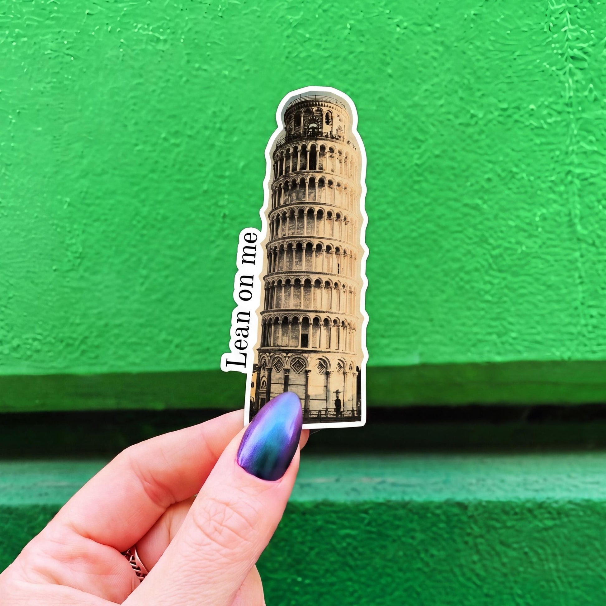 A die-cut sticker featuring a sepia-toned illustration of the Leaning Tower of Pisa and the text 'Lean on me'.