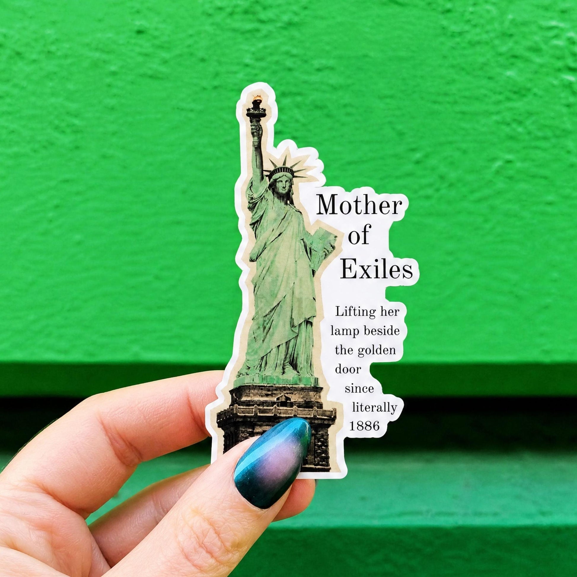 A die-cut sticker featuring a green Statue of Liberty illustration and the text 'Mother of Exiles' and 'Lifting her lamp beside the golden door since literally 1886.'